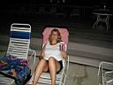 /hh/P1010018.jpg: Denise drinking Bud Light at the pool at night